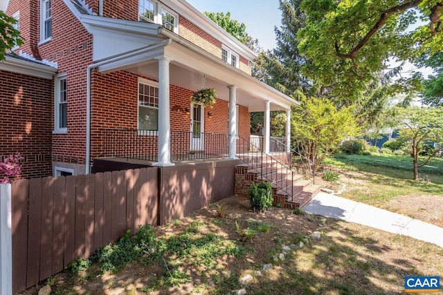 view of front of home with a porch and brick siding