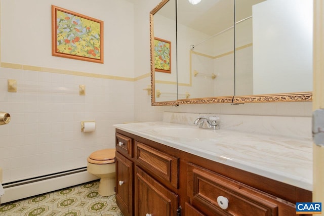 full bath featuring tile walls, baseboard heating, walk in shower, vanity, and toilet