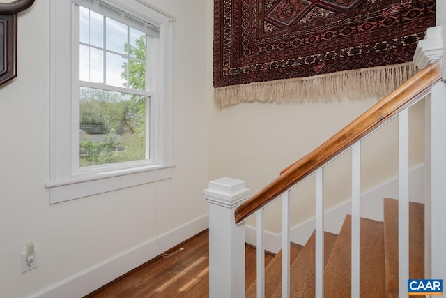 staircase featuring baseboards and wood finished floors