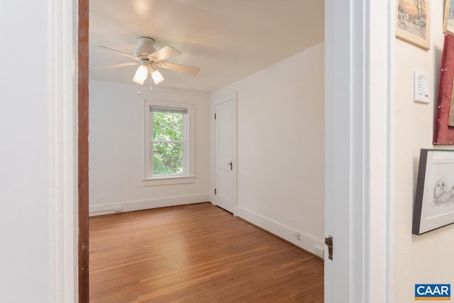 unfurnished room featuring baseboards, a ceiling fan, and wood finished floors