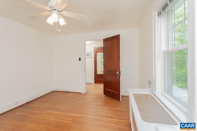 empty room with light wood-style floors, baseboards, plenty of natural light, and ceiling fan