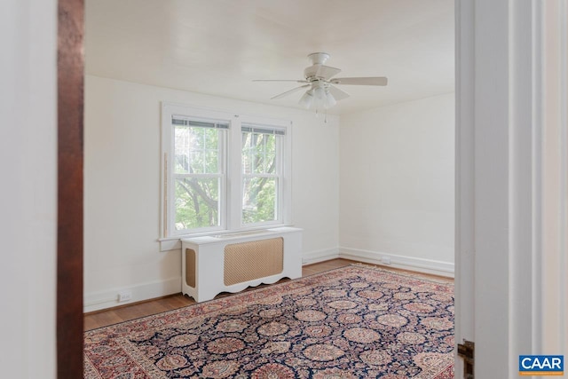 spare room with a ceiling fan, baseboards, and wood finished floors