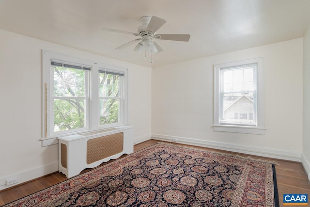 unfurnished room with a ceiling fan, baseboards, and wood finished floors