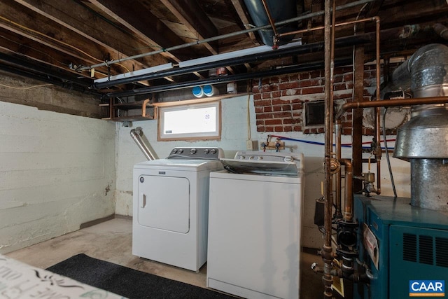 laundry room with a heating unit, laundry area, and washing machine and clothes dryer