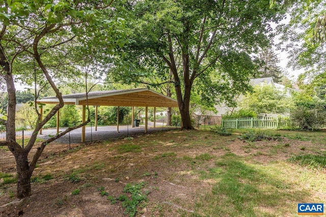 view of yard featuring fence and a carport