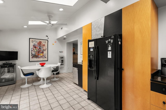 15708 Thompson Rd, Silver Spring, MD 20905 - kitchen with black fridge with ice dispenser, a skylight, vaulted ceiling, ceiling fan, and recessed lighting
