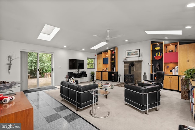 15708 Thompson Rd, Silver Spring, MD 20905 - living room featuring a skylight, a wood stove, recessed lighting, vaulted ceiling, and a ceiling fan