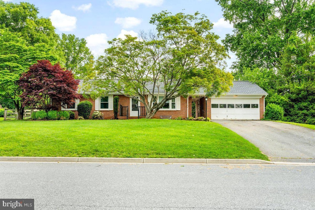 5 Locust Blvd, Middletown, MD 21769 - view of property hidden behind natural elements with a garage, asphalt driveway, brick siding, and a front yard