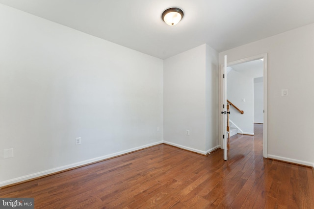 spare room featuring wood finished floors and baseboards