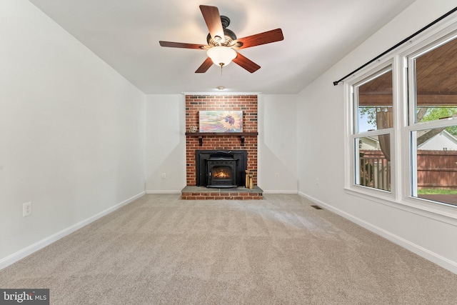 unfurnished living room with carpet flooring, a ceiling fan, healthy amount of natural light, and baseboards
