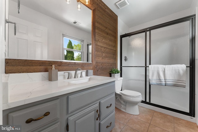 bathroom with vanity, a shower stall, tile patterned flooring, and toilet