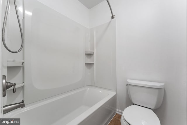 bathroom with toilet,  shower combination, and tile patterned floors