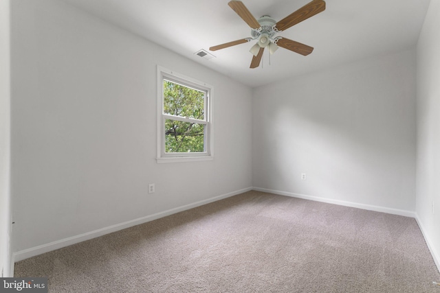 empty room featuring carpet, baseboards, and a ceiling fan