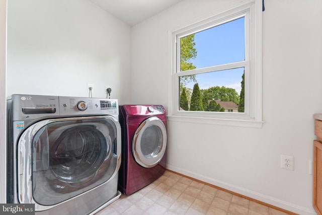 washroom featuring washer and dryer and baseboards