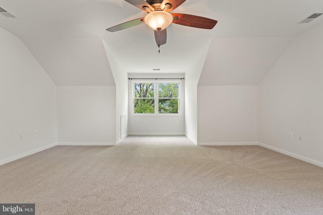 additional living space featuring carpet, lofted ceiling, baseboards, and a ceiling fan