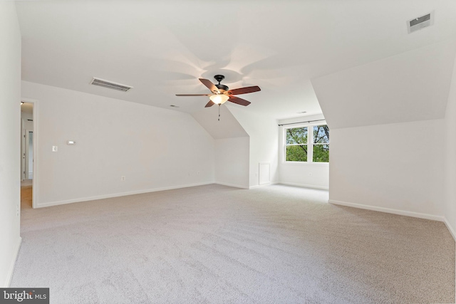 bonus room with ceiling fan, light colored carpet, baseboards, and vaulted ceiling