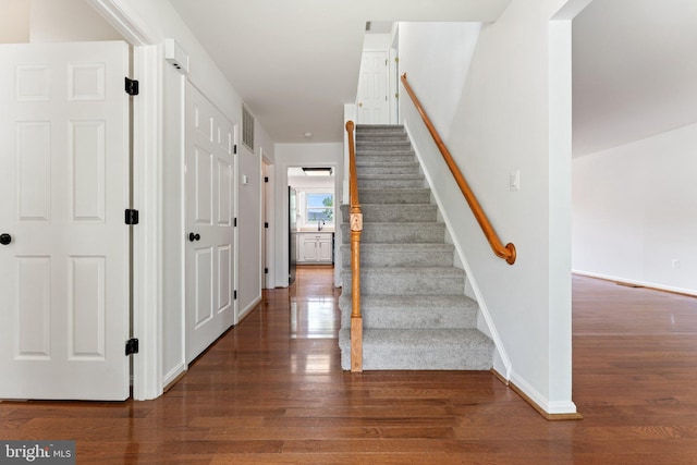 stairway featuring wood finished floors and baseboards