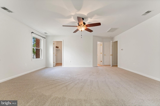 spare room with ceiling fan, light carpet, and baseboards