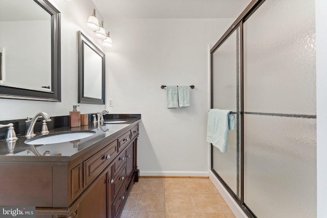 full bathroom featuring a shower stall, tile patterned flooring, baseboards, and double vanity