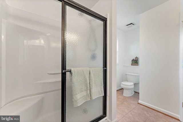 bathroom with baseboards, tile patterned flooring, a stall shower, and toilet