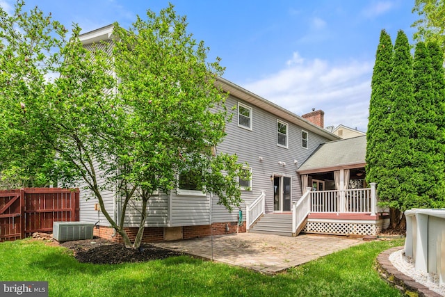 back of property with a patio area, central AC unit, and a deck