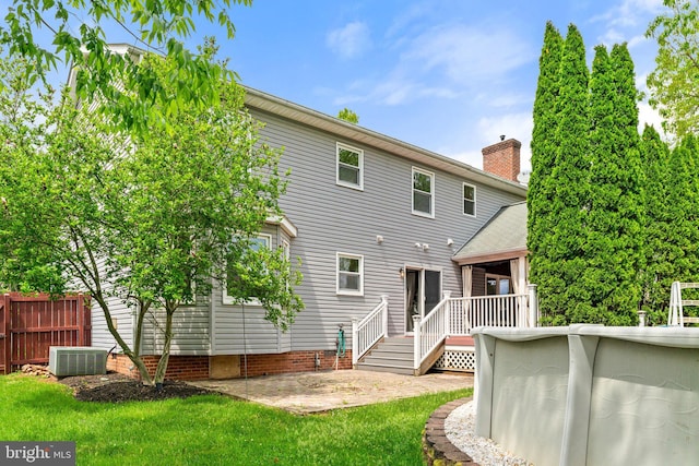 back of property featuring a patio, central AC, and a chimney