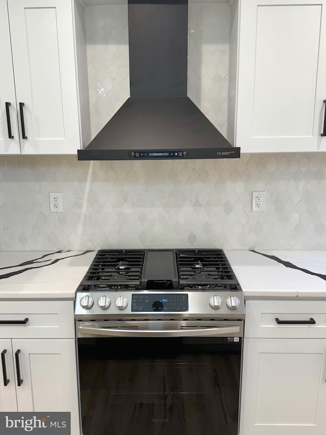 5135 N Fairhill St, Philadelphia, PA 19120 - kitchen featuring stainless steel gas range, wall chimney range hood, white cabinetry, light countertops, and tasteful backsplash