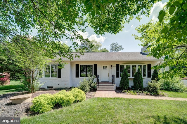 single story home featuring a front yard, roof with shingles, and brick siding