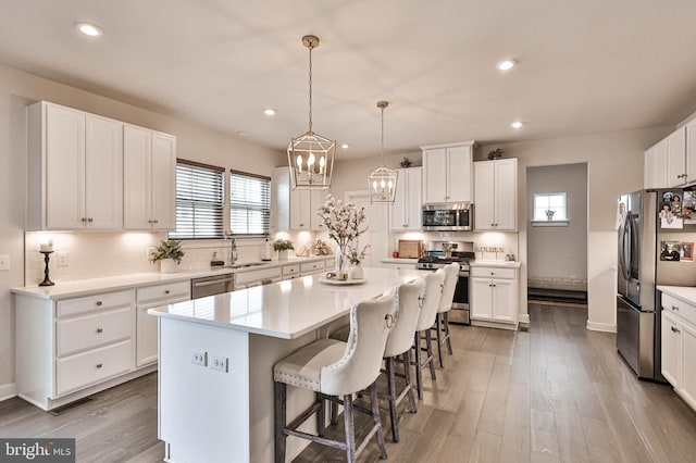 3911 Dewalt St, Bethlehem, PA 18020 - kitchen featuring a center island, white cabinetry, appliances with stainless steel finishes, and a kitchen breakfast bar