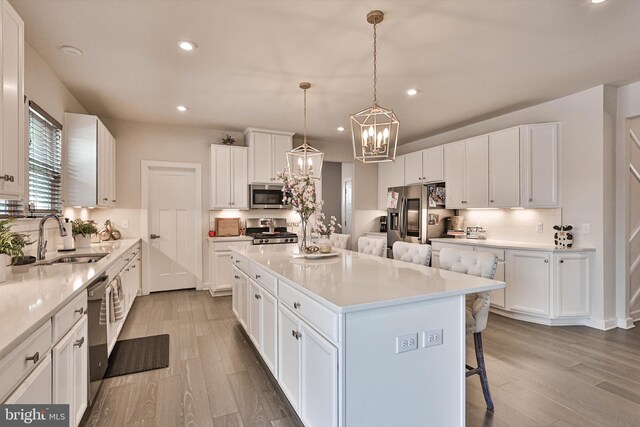 3911 Dewalt St, Bethlehem, PA 18020 - kitchen featuring a center island, stainless steel appliances, a kitchen bar, and wood finished floors