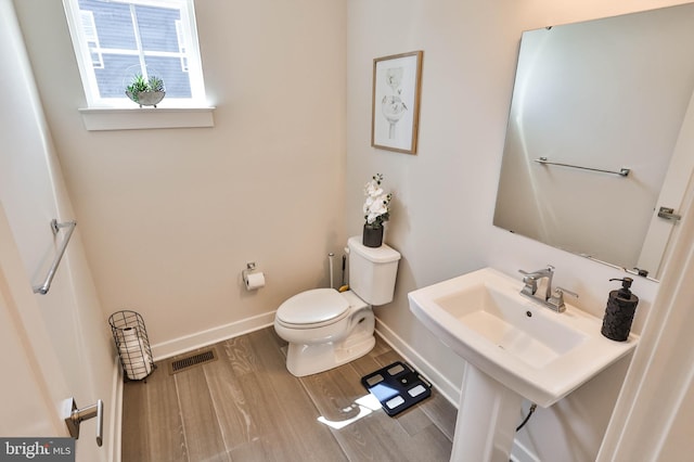 3911 Dewalt St, Bethlehem, PA 18020 - half bath featuring toilet, baseboards, visible vents, and wood finished floors