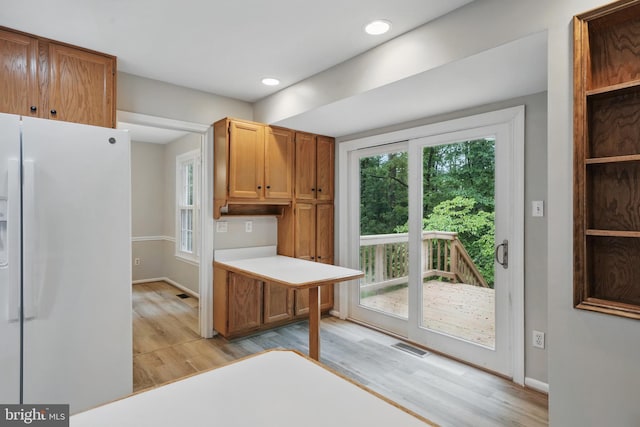 kitchen featuring freestanding refrigerator, light wood-style flooring, light countertops, recessed lighting, and baseboards