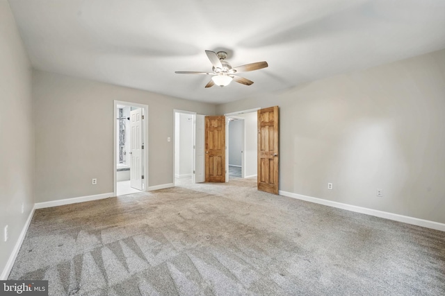 empty room with ceiling fan, carpet, and baseboards