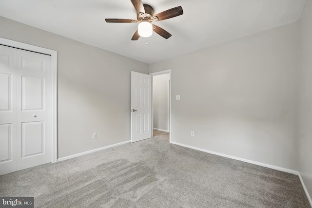 unfurnished bedroom featuring carpet floors, baseboards, a ceiling fan, and a closet