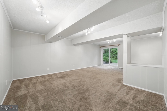 spare room with track lighting, a textured ceiling, carpet flooring, and baseboards