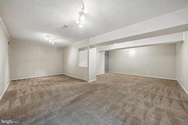 finished basement with carpet flooring, a textured ceiling, and baseboards