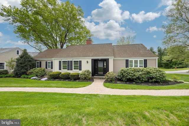 ranch-style house with a chimney and a front yard