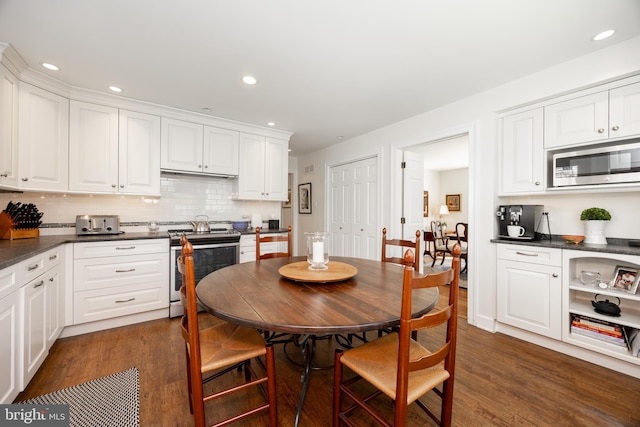 kitchen featuring dark countertops, stainless steel appliances, and dark wood-style flooring