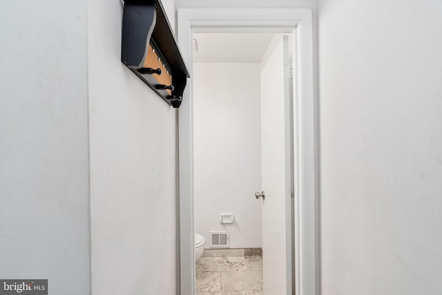 bathroom featuring toilet and baseboards
