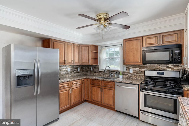 kitchen featuring stainless steel appliances, brown cabinets, a sink, and crown molding