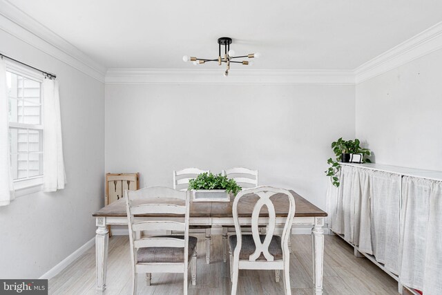 dining area with ornamental molding, a chandelier, baseboards, and wood finished floors