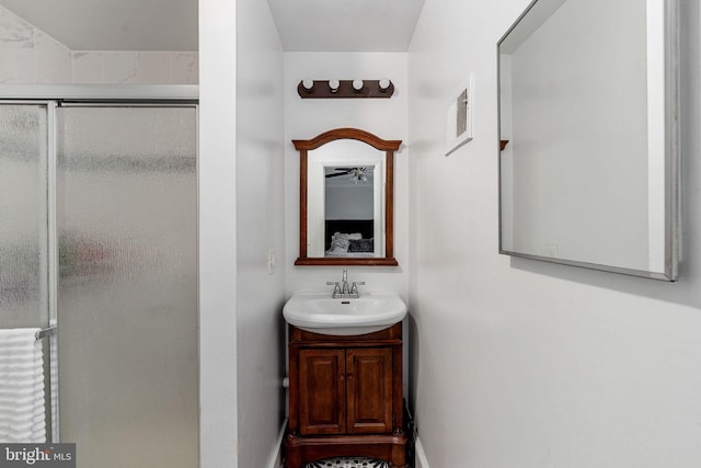 bathroom with a stall shower, vanity, and baseboards