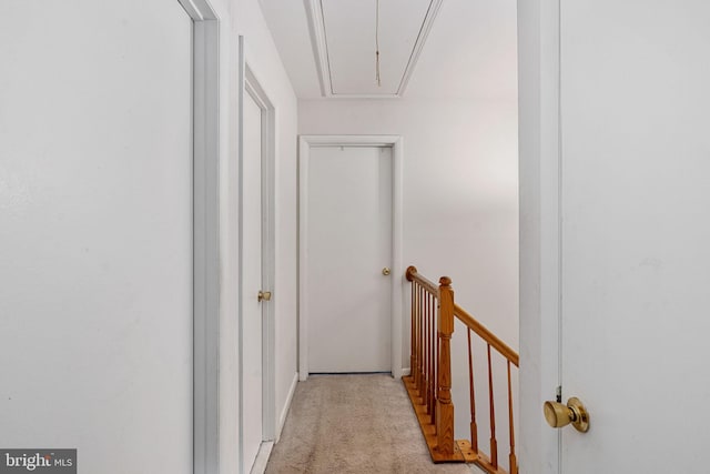 hall with attic access, light carpet, and an upstairs landing