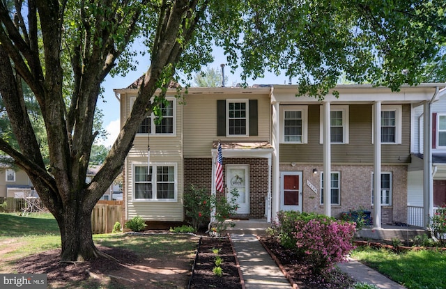 view of front of house featuring fence and brick siding