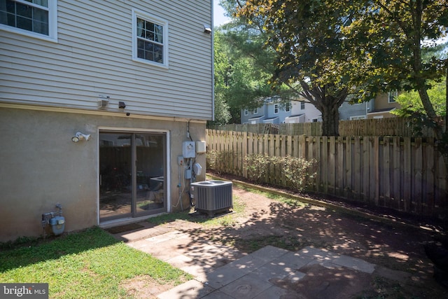 view of yard featuring fence, central AC, and a patio area