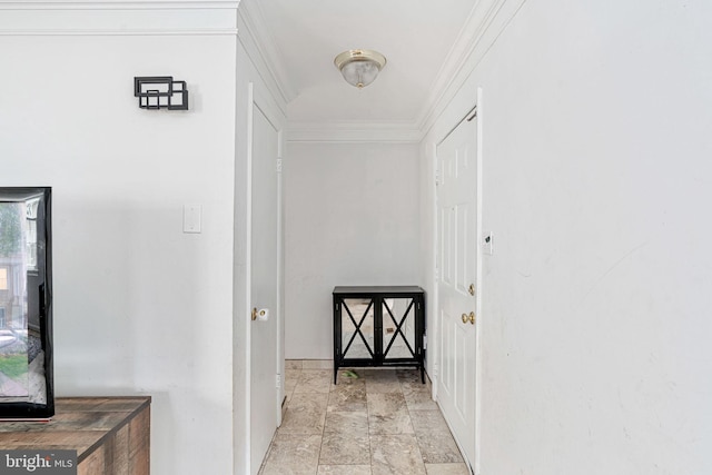 hall featuring light stone finish floors, baseboards, and ornamental molding