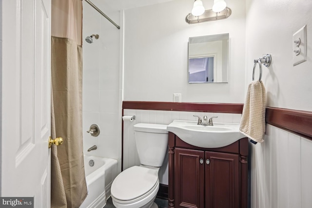 full bath featuring vanity, toilet, shower / bathtub combination with curtain, and a wainscoted wall