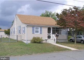 view of front of property featuring fence, a gate, a porch, and a front lawn