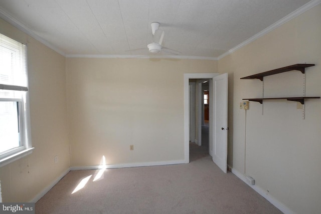 unfurnished bedroom with carpet flooring, a ceiling fan, crown molding, and baseboards