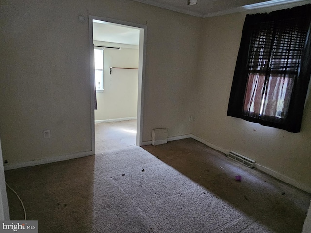 empty room featuring carpet floors, baseboards, and visible vents